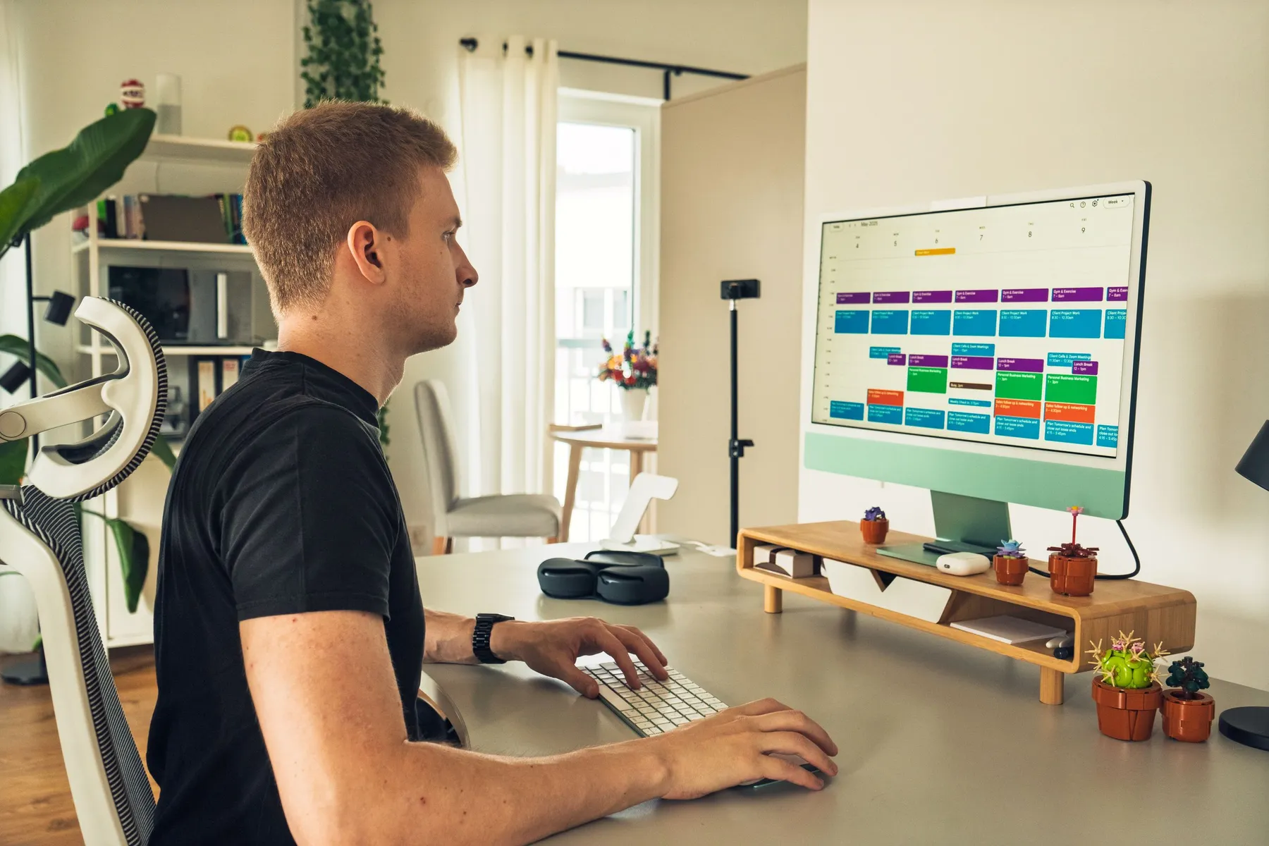 Eric Schejnoha am Schreibtisch vor dem Bildschirm mit Wochenkalender